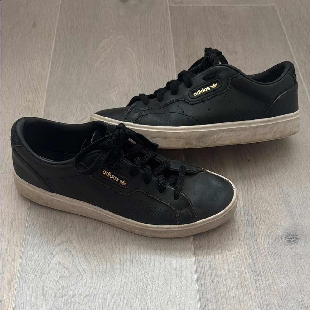 Black Adidas Leather Sneakers with White Soles and gold accents.